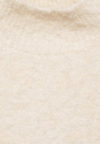 Pullover morbido in crema con un motivo di maglia testurizzata, dotato di un collo a coste. Il tessuto appare caldo e soffice, adatto per il freddo.