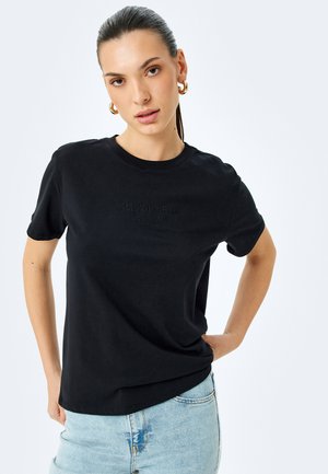 Sort bomulds t-shirt med korte ærmer, prydet med præget tekst "ALL YOU NEED IS LOVE" foran, rund hals og afslappet pasform.