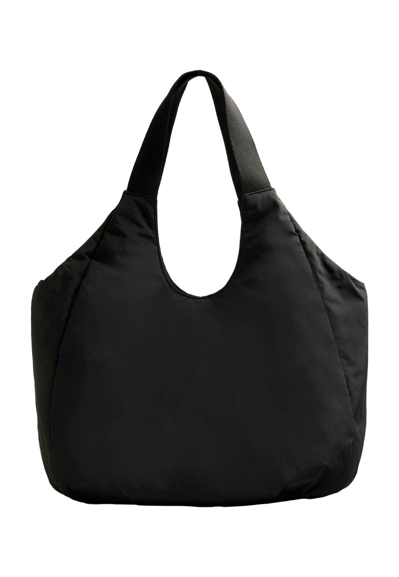 Black oversized tote bag with a smooth, matte finish, wide shoulder strap, and rounded opening for easy access.