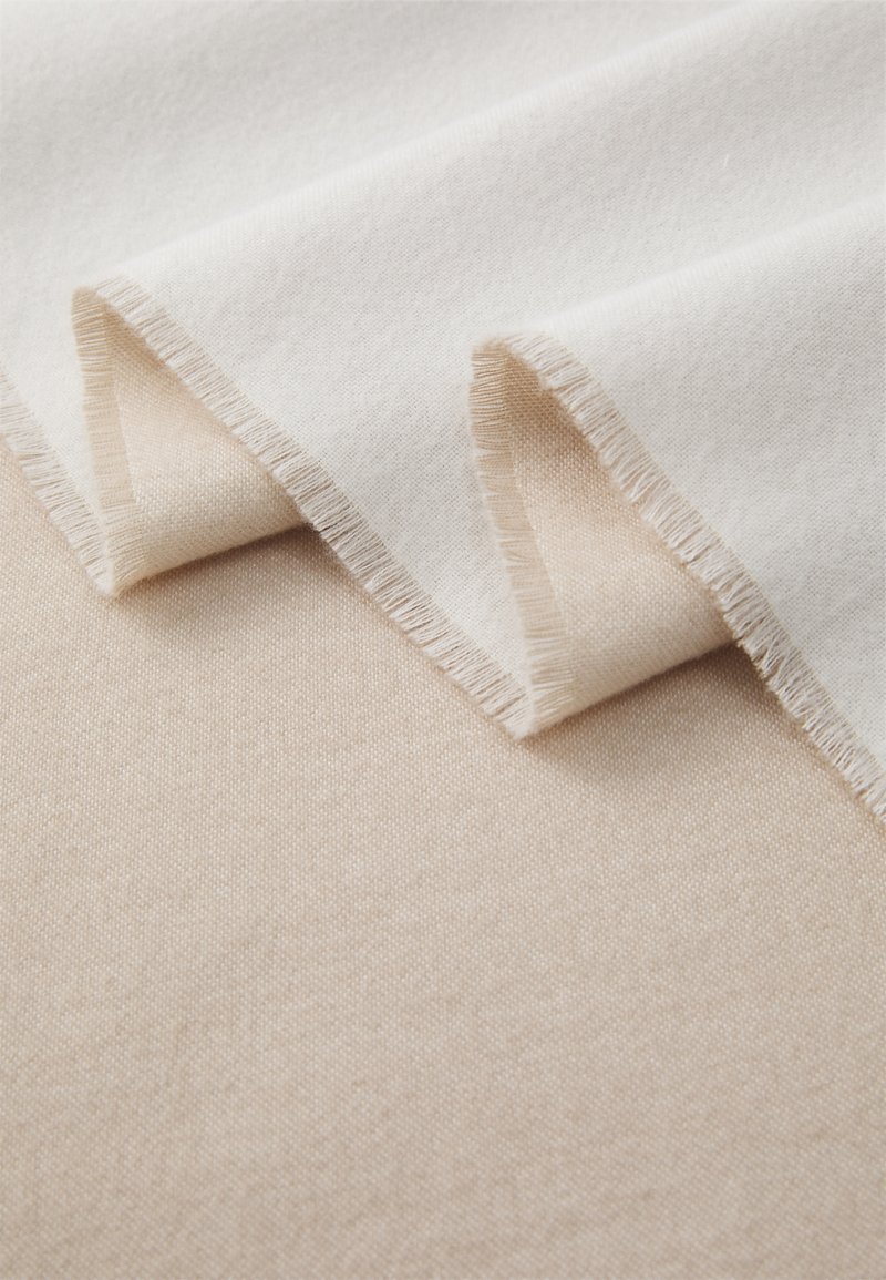 Beige and off-white fabric layers, soft texture, featuring frayed edges and a smooth finish. A neutral color palette with subtle shading.