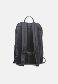 Sac à dos noir avec des bretelles rembourrées en mesh, des compartiments zippés et une boucle de poitrine ajustable. Dispose d'une poignée supérieure solide.