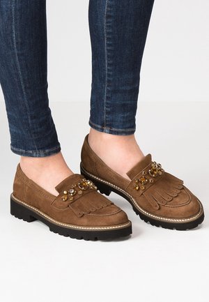 Bruine suède loafers met een franjes ontwerp, versierd met juwelen, een dikke zwarte zool en een contrasterende stiknaad langs de rand.