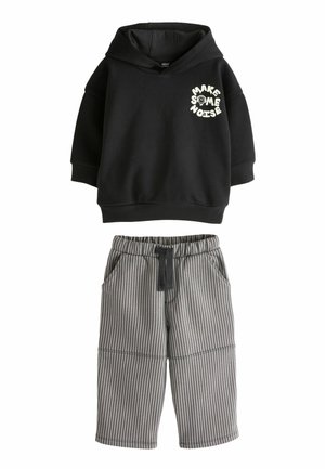 Black hoodie with "MAKE SOME NOISE" text and a skull graphic; paired with gray striped shorts featuring an elastic waist and pockets.