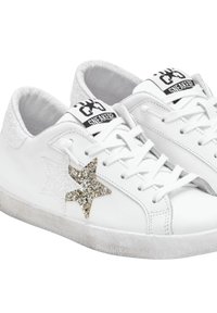 Sneaker bianchi con finitura testurizzata, caratterizzati da un dettaglio a forma di stella dorata glitterata e una superficie liscia. Marchio nero sulla linguetta.