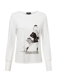 White long-sleeve shirt with a black graphic print of a stylish figure. Features a round neckline and gathered cuffs. Soft, textured fabric.