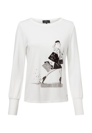 White long-sleeve shirt with a black graphic print of a stylish figure. Features a round neckline and gathered cuffs. Soft, textured fabric.
