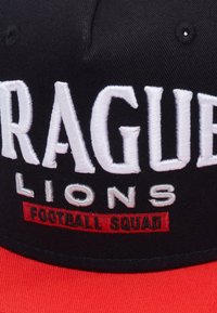 Black cap with red visor featuring embroidered white text "PRAGUE LIONS" and "FOOTBALL SQUAD" in red. Text has large, bold letters.