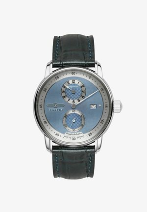 Montre chronographe en argent avec un cadran texturé bleu, deux sous-cadrans, et un bracelet en cuir vert foncé, arborant un boîtier en acier inoxydable poli.