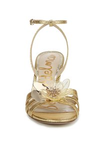 Gouden metallic hoge hak sandaal met een bloemversiering, open teen ontwerp, dunne enkelband en gekruiste banddetails.