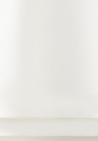 Bílé látkové pozadí s jemnou svislou žebrovanou strukturou a měkkými záhyby u dolního okraje.