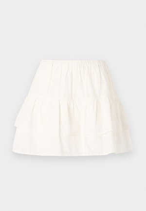 White tiered skirt made of cotton with eyelet embroidery, featuring an elastic waistband and a lightweight, textured fabric.