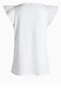 Camiseta de algodón blanca con mangas cortas de encaje decorativo de ojales. Textura suave, escote redondo y dobladillo recto.