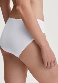 Weißer Baumwollslip mit nahtlosem Design, mittelhohem Schnitt, glatter Textur und flexiblem Bund für Komfort.