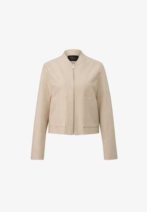 Beżowa krótka kurtka z długimi rękawami, przednim zamkiem błyskawicznym, dwoma dużymi prostokątnymi kieszeniami i okrągłym kołnierzem.