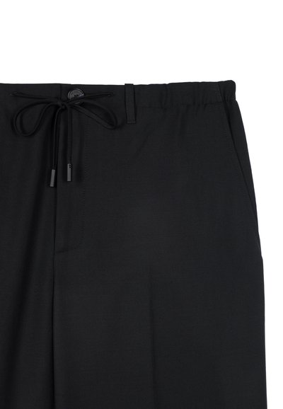 Zwarte elastische taillebandbroek met een trekkoordsluiting, voorzien van twee zijzakken en een gladde, lichte stof. 