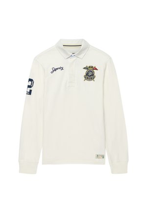 Wit poloshirt met lange mouwen met geborduurde "Superdry" tekst op de borst, marineblauwe nummerpatch op de rechtermouw en een meerkleurig wapen op de linkerborst.