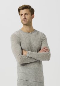 Lys grå langermet T-skjorte laget av mykt, strukturert stoff, med rund hals og tettsittende design.