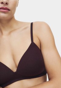 Bralette triangular burdeos con tirantes finos, confeccionado en una tela suave, que presenta una textura lisa y sin herrajes ni adornos visibles.