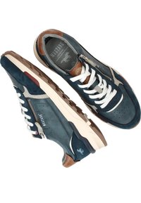 Zapatillas de ante azul oscuro con suela beige. Las características incluyen cordones blancos, un zipper lateral y acentos de cuero marrón en el talón.