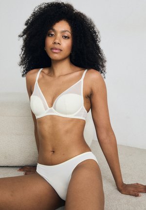 Ensemble de lingerie blanche comprenant un soutien-gorge en mesh doux avec des bonnets moulés et des fines bretelles, associé à une culotte hipster lisse assortie.