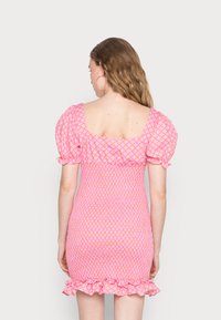 Vestido curto rosa com decote quadrado, mangas bufantes, tecido franzido, padrão floral e bainha com volantes.