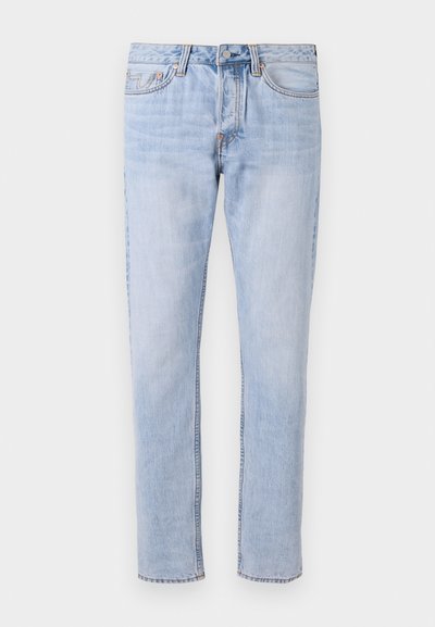 Jean en denim bleu clair avec une jambe droite, un design à cinq poches et des coutures renforcées le long des coutures. Fermeture classique à boutons et à zip.