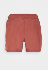 Roestkleurige shorts met elastische taille, gemaakt van een gladde stof en met een rechte zoom, weergegeven vanuit de achterkant op een witte achtergrond.