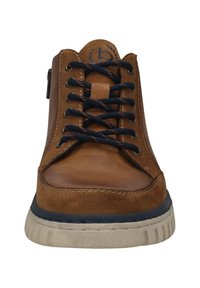 Braune Ledersneaker mit marineblauen Schnürsenkeln, Gummisohle und runder Zehenpartie. Merkmale eine kontrastierende beige Sohle und ein einfaches Logo auf der Zunge.