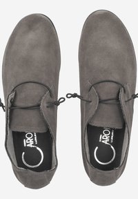Chaussures en daim gris avec une texture lisse, forme arrondie et accents de lacets noirs. Semelles plates et branding subtil sur les semelles intérieures.