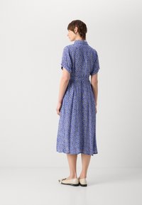 Vestido azul com padrão, mangas curtas, cintura ajustada e saia fluida. Design notável em forma de diamante em cores contrastantes, até ao joelho.