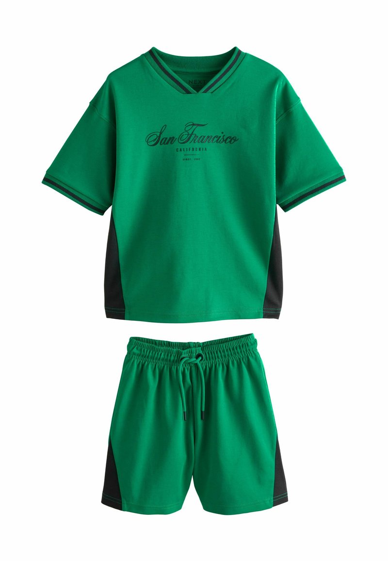 Completo di top a maniche corte e pantaloni corti in misto cotone verde. Il top presenta pannelli laterali neri e una stampa "San Francisco". Vita elastica sui pantaloni.