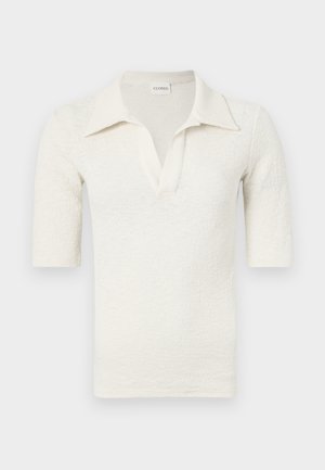 Baltas, trumpomis rankovėmis polo marškinėliai su tekstūrinėmis medžiagomis, turintys išpjautą apykaklę ir V formos iškirptę. Etiketė: CLOSED.