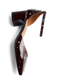 Zapato de tacón cuadrado de charol marrón con tira en el tobillo, que presenta tachuelas plateadas y un diseño de punta afilada. Superficie lisa y silueta curvada.