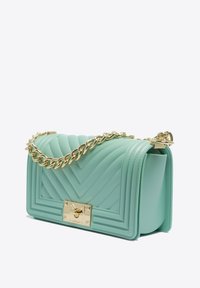 Borsa a tracolla trapuntata azzurro chiaro con catena dorata, forma strutturata e base rettangolare. Presenta una chiusura dorata sul davanti.