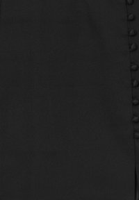 Tissu noir avec une texture lisse, présentant une rangée de petits boutons le long du bord droit. Design simple sans motifs supplémentaires.