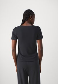 Svart kortermet topp laget av glatt stoff med avslappet passform og firkantet utringning, med et rent, minimalistisk design.