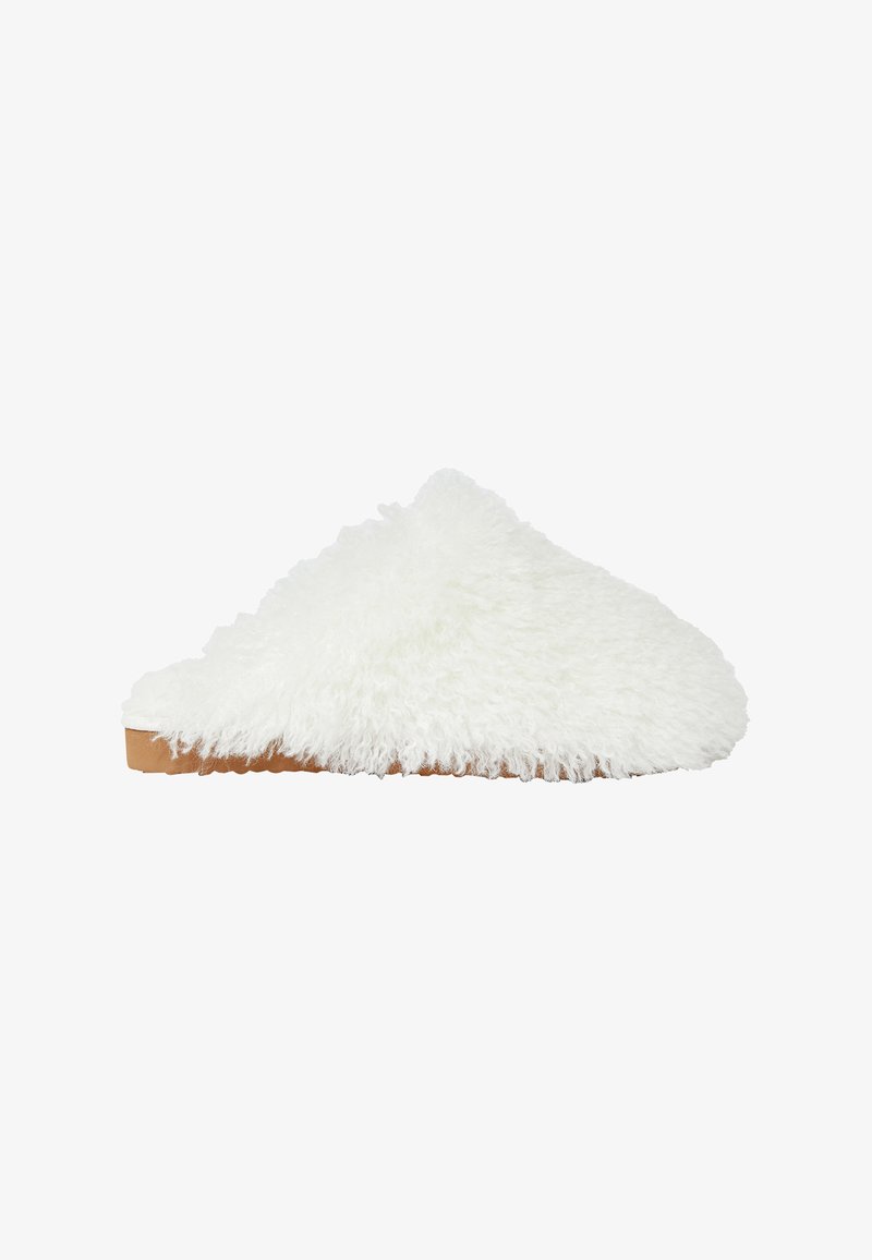 Pantofole bianche soffici senza risvolti con una texture pelosa e suola in gomma marrone chiaro, caratterizzate da una punta arrotondata e senza elementi metallici visibili.