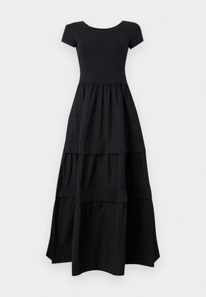 Robe maxi noire à manches courtes avec corsage cintré et jupe fluide à volants s'étendant jusqu'au sol sur un fond clair.