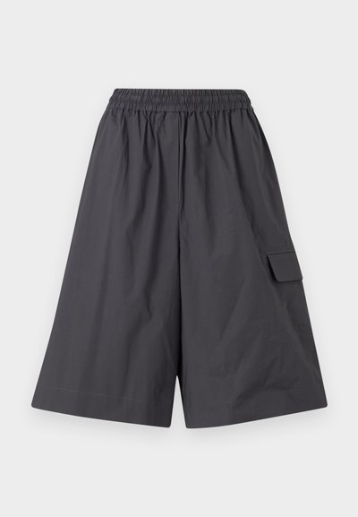 Tumši pelēki šorti ar elastīgu jostu, plakanu priekšpusi un sānu kabatu. Izgatavoti no viegla auduma. Brīvi, plata kāju dizains.