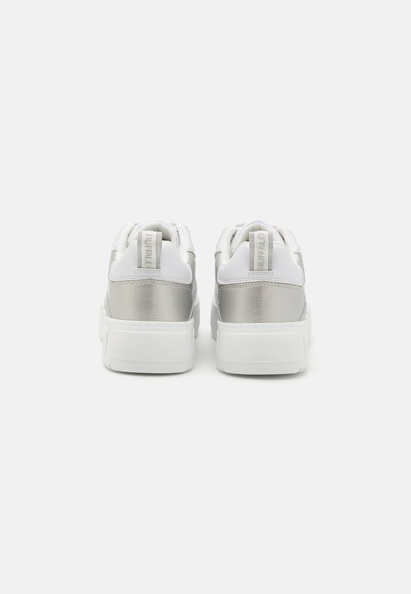 Par de zapatillas blancas con acentos plateados en el talón y tiradores con la marca "BUFFALO", vistas desde la parte trasera sobre un fondo blanco.