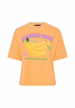 Oranssi lyhythihainen T-paita, jossa grafiikka banaaniryhmästä ja tekstit "Luonnollisesti makea", "Herkullinen" sekä "Täynnä aurinkoa ja hyvyyttä".