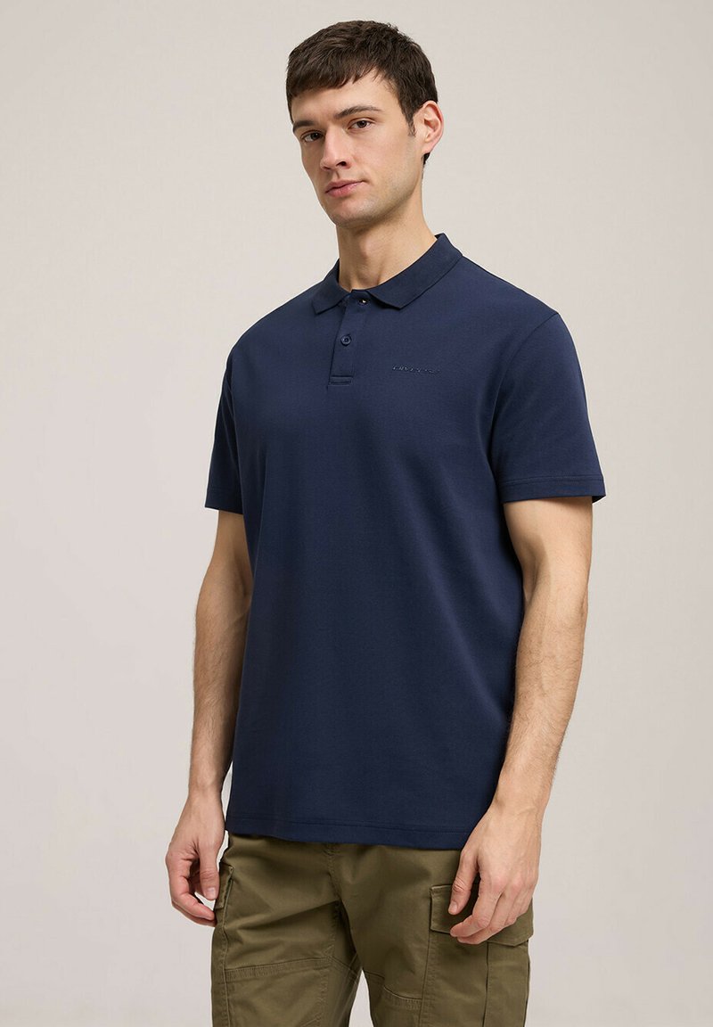 Granatowa koszulka polo z klasycznym kołnierzykiem i trzema guzikami, wykonana z gładkiego materiału, z krótkimi rękawami i wytłoczonym logo.