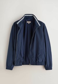 Veste légère bleu marine zippée avec poignets et ourlet élastiques, devant ouvert et col avec deux bandes blanches.