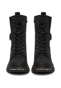 Melnas lace-up zābaki ar strukturētu ādas virsma, zelta toņa detaļas un izturīga zole, kurai ir metāla stripa elements purngalā.