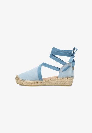Espadrilla in suede azzurro chiaro con suola in juta. Presenta cinturini incrociati in tessuto alla caviglia e una punta arrotondata.