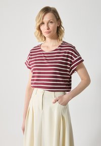 Maroon and cream striped short-sleeve shirt with a rounded neckline, paired with high-waisted, pleated cream trousers. Smooth fabric texture.