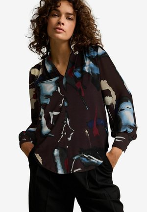 Langarmblouse van donkere stof met een abstract meerkleurig patroon. Heeft een V-hals en geplooide manchetten, zachte draping, en een relaxte pasvorm.