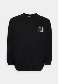Felpa nera con maniche lunghe, scollo rotondo e polsini a coste. Presenta un piccolo design con tasca e elementi grafici bianchi. Tessuto morbido.