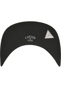 Must musträpp, millel on kõver serv, millel on valge "CAYLER & SONS" logo ja kolmnurkne peegeldav aktsent. Tekstuuriga kangas, millel on nähtavad õmblused.