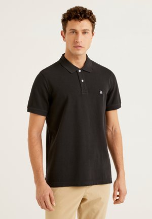 Camisa polo negra con cuello, que presenta un tapón de tres botones y un logo bordado en el pecho. Material de algodón, de manga corta.